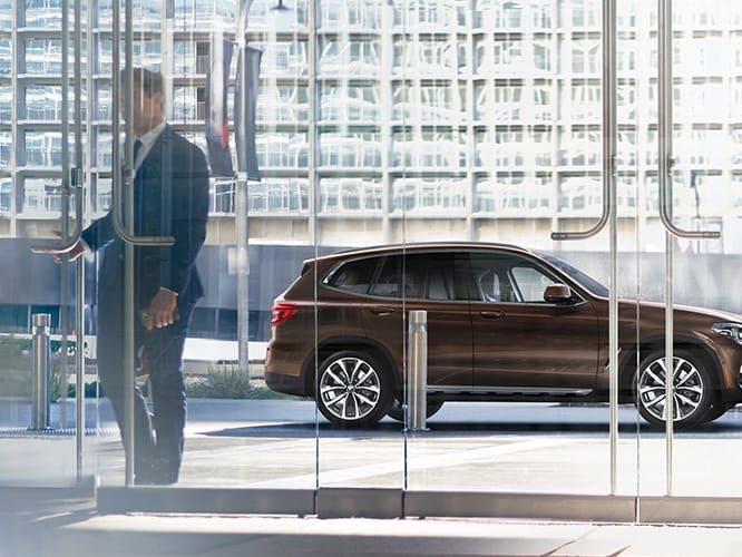 The BMW X5 M50i in Arctic Grey Metallic cruising through the city