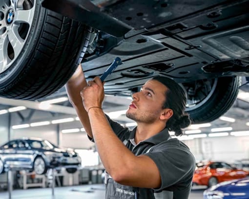BMW technician inspecting a Certified Pre-Owned BMW