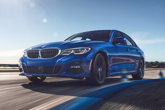 A BMW driving down a scenic highway on a sunny day