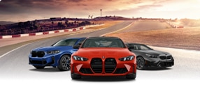 Three BMW High-Performance M vehicles parked near each other in front of a racetrack