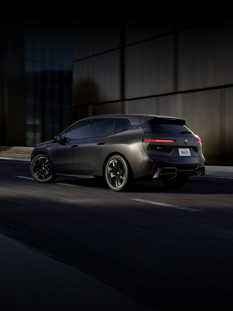 The BMW XM Label driving in a dramatic night time shot.