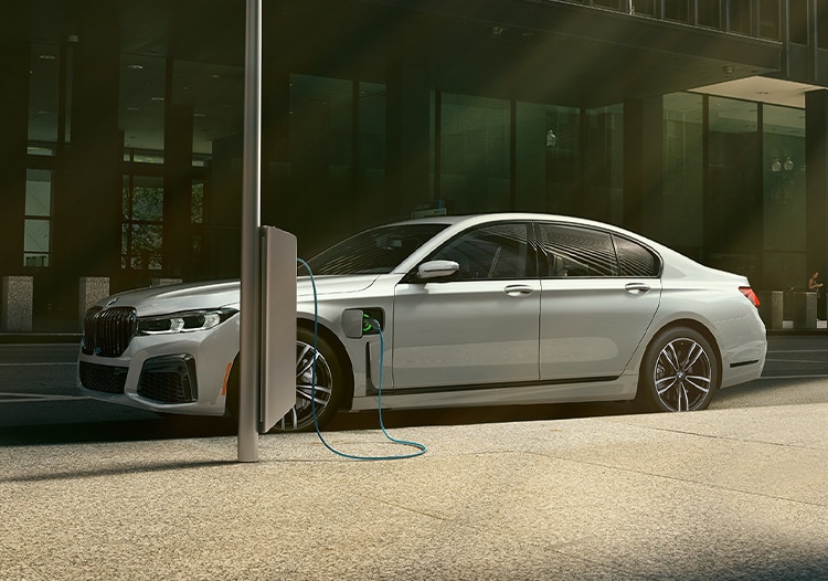 A BMW Certified 7 Series 745e plug-in hybrid parked while charging on the street
