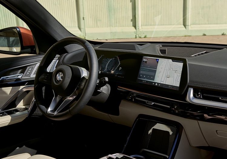 Driver's side front interior of X1 SUV showing steering wheel and dashboard