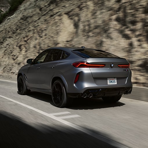 Rear shot of the 2026 BMW X6 M Competition SUV driving on a highway