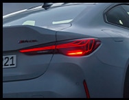 Rear action shot of the Limited Edition BMW M4 CSL, driving on an open road – showcasing new taillights with laser technology