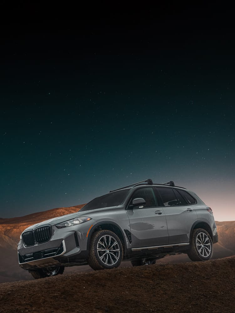 The Silver Anniversary Edition X5 SUV parked under a starry sky in the mountains